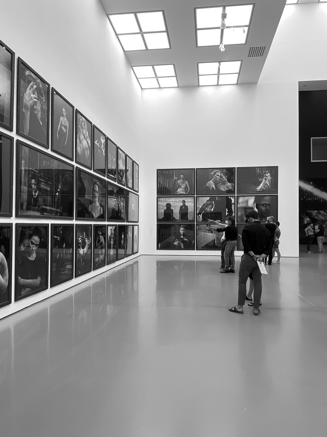 Besucher des Museums betrachtet die großen Fotos des weltbekannten Fotografen (Bild in schwarz-weiß)